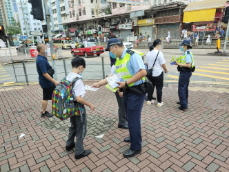 警员派发宣传单张，呼吁学童及家长善用过路设施小心过马路。 警方图片
