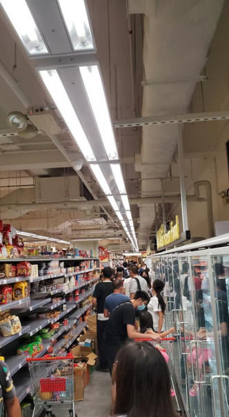 有超市分店，晚上仍有不少顾客排队购物。