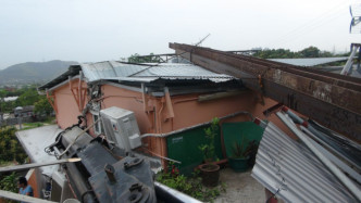 村屋屋頂被壓毀。林思明攝