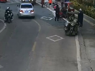 三輪車最後停在路旁，疑犯被帶走。網上影片截圖
