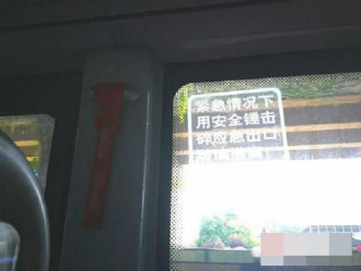 男子取下了一个挂在车上的红色安全锤，砸碎了巴士车窗。网图