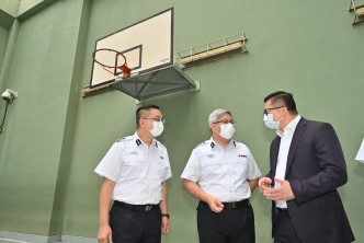 邓炳强（右）听取入境事务处人员简介羁留人士日常活动。政府新闻处图片