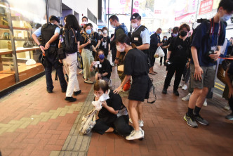 一名身穿黑衣的老妇被警员截查后情绪激动。