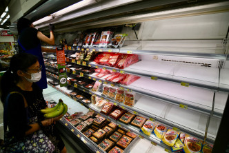 大批市民到超市抢购，食品货架被抢清空。