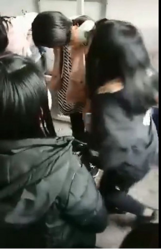 被圍毆的女學生掩住臉。網圖