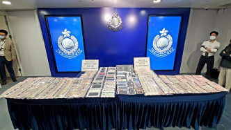 警方展示检获的现金及手提电话等证物。林思明摄