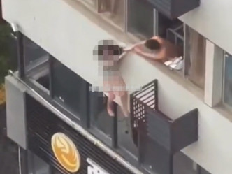 睡衣的女子坐在窗边，与一名上身半裸的男子不断拉扯。微博图片