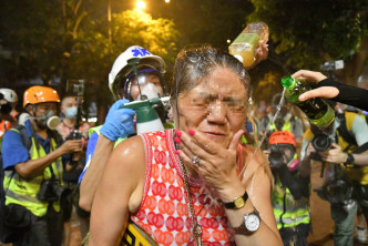 一名妇人阻碍警员驱散被喷催泪水剂