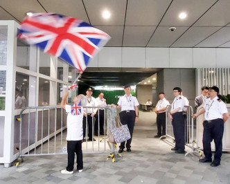 一名女子在政总门外挥舞英国旗。
