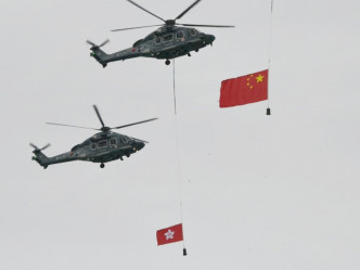 政府飛行服務隊直升機展示大型國旗和區旗。