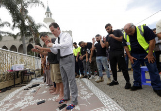 邻国澳洲，人们都在街上及商铺站立默哀，悼念死者。　
AP图片