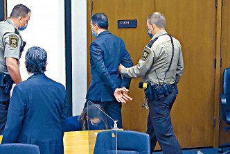肖萬（中）被判罪成後被庭警鎖上手扣帶離法庭。