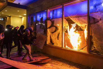 示威者破壞商店。 AP
