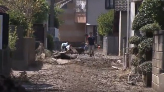 居民忙於清理街道淤泥。網上圖片