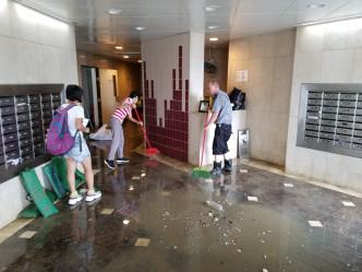 杏花邨近海的大廈，今日仍有積水，工作人員忙於清理。
