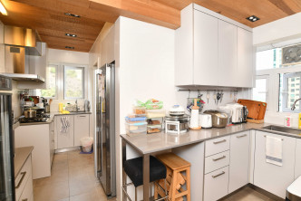 廚房整體空間修長，設有多組廚櫃及吊櫃。