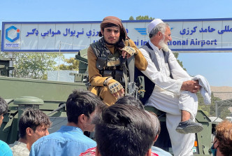 塔利班武装分子在机场外围驻守。路透社图片