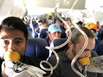 左引擎在空中爆炸後，西南航空的乘客都戴上氧氣面罩，祈禱平安降落。（網圖）