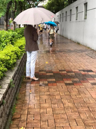 小學校長撐傘為母子擋雨。Moon Choo圖片