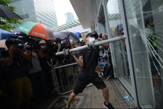 示威者以硬物冲击玻璃门。