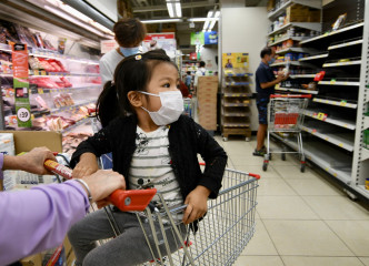 大批市民到超市抢购，食品货架被抢清空。