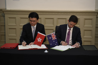 邱騰華（左）在澳洲悉尼與澳洲貿易、旅遊和投資部長伯明翰簽署香港與澳洲《自由貿易協定》和《投資協定》。 政府圖片