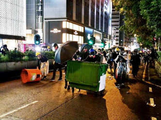 示威者以垃圾桶堵塞道路。