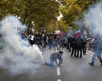 防暴警察手持警棍警盾用催淚彈驅散民眾。AP