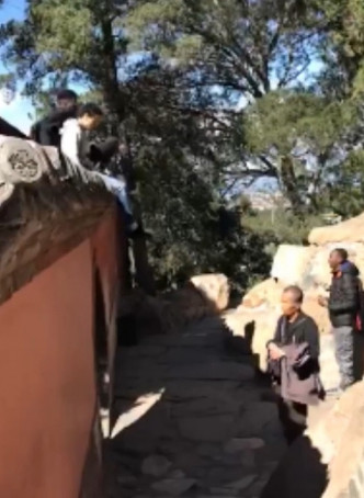 上月有2名游客爬上颐和园围墙拍照，更踩碎瓦片。网图