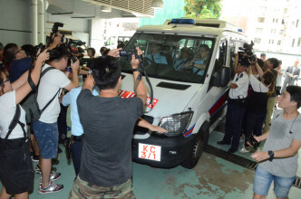 大批记者包围警车拍摄。