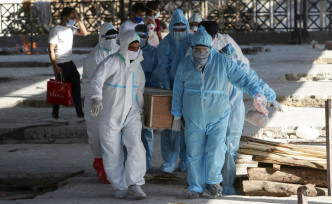 印度工作人員火化新冠肺炎死者遺體。AP圖片
