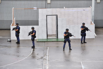 特警组分别示范游绳下降、高空攻击及以警犬制伏等战术。郭显熙摄