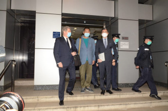 黎智英由两名外籍律师陪同离开西九总部。