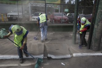 國家災難協調人員在清理受火山灰影響的路面。AP