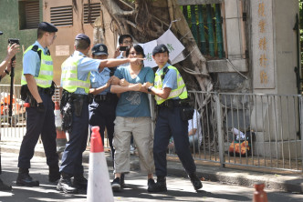 一名女子激动走出马路，由警员带返安全位置。
