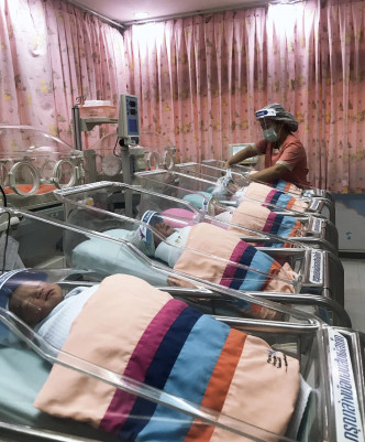 泰国一间医院为新生婴儿戴上透明防护面罩。 AP图