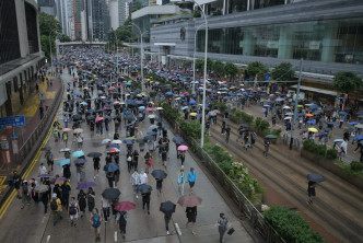 大批示威者撐起傘冒雨遊行。