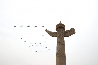 戰機飛越天安門上空，組成「100」、「71」及「人」字形編隊。新華社圖片