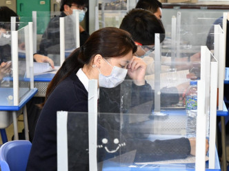 课室的学生桌用透明胶板分隔学生。