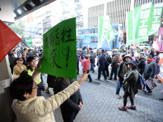 有不同意見人士在遊行隊伍旁抗議。