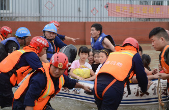 救援隊用衝鋒艇開入鎮上救援。 新華社