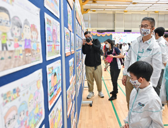 警务处处长萧泽颐（右二）欣赏「亲子填色及口号创作比赛」的参赛作品。政府新闻处图片