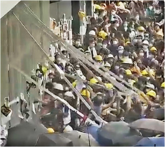 大批示威者拆除立法會外圍大型鐵欄。有綫新聞圖片