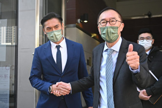 潘梓锋（左）离开法院时与资深大律师清洪握手。