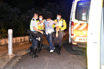 杨明烂醉如泥，由警员扶上救护车。