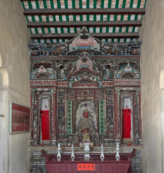協天宮後進明間神龕的三層彩色花罩配有手工精細的鏤雕花卉、動物和吉祥物圖案。