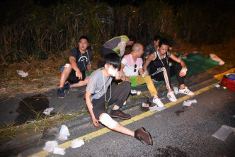 伤者坐在路边等待救援。