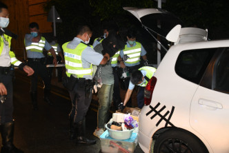 警员押该男子搜查私家车。