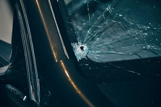 子弹击中私家车车头挡风玻璃右下角。