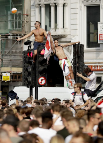 在倫敦大批英格蘭球迷爬上路牌、雙層巴士瘋狂慶祝。AP
